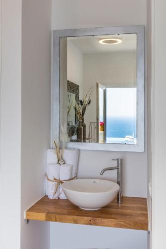 a bathroom with a sink and a mirror at Villa Semeli Syros by Divine Property SA in Ano Syros