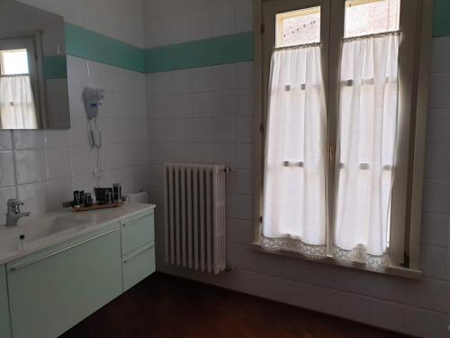 a bathroom with a sink and a window at Locanda Al Portone in Scandiano