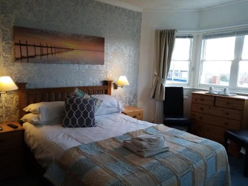 Habitación de hotel con cama, silla y ventanas en The Kenton Hotel, en Scarborough