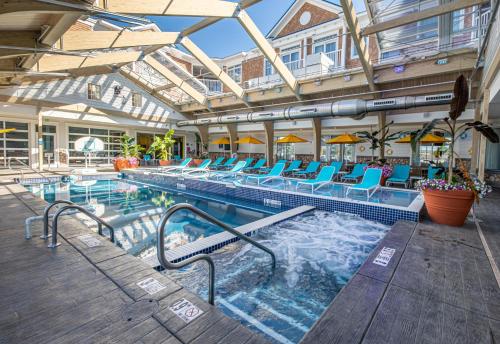 a swimming pool with blue chairs in a building at Hotel LBI in Ship Bottom