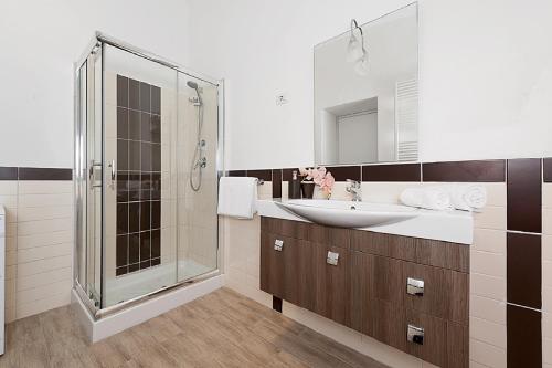 y baño con ducha acristalada y lavamanos. en BMGA l Mon Amour San Giovanni Apartment, en Roma