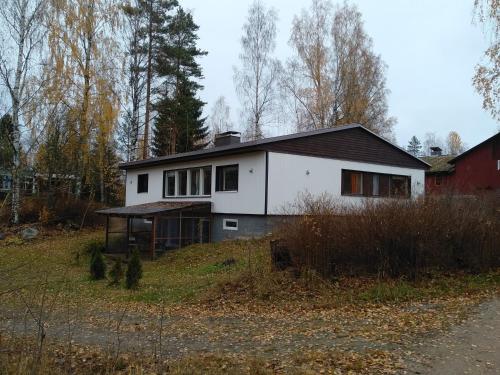 a white house sitting on top of a field at Cottage Viardo in Vehkataipale