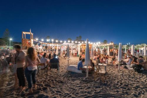 a crowd of people on a beach at night at Le Palmette Suites in Cagliari