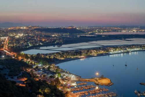 an aerial view of a city and a lake at night at Le Palmette Suites in Cagliari