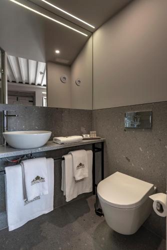 a bathroom with a toilet and a sink with towels at Porta Nova Collection House in Braga