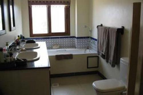 a bathroom with a tub and a sink and a toilet at Blue Bay Cove, Penthouse 4 in Watamu