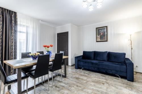 a living room with a blue couch and a table at Villa Gor Apartments in Bukovel