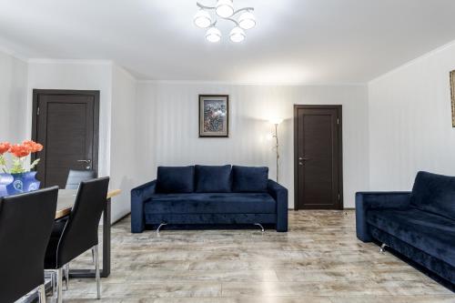 a living room with blue couches and a table at Villa Gor Apartments in Bukovel