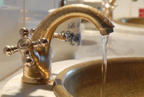 a kitchen sink with water running from a faucet at Le Palais des Cerisiers in Azrou