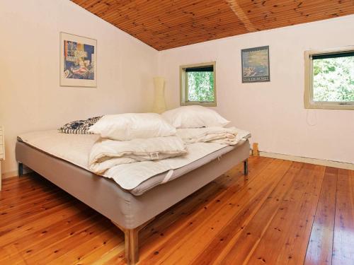 uma cama grande num quarto com piso em madeira em Holiday home Asnæs VII em Asnæs