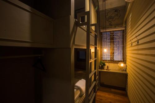 a hallway with a bathroom with a window and a sink at Azure Hostel Bangkok in Bangkok