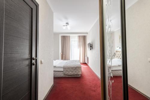 a room with two beds and a red floor at Villa Gor Apartments in Bukovel