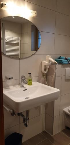 a bathroom with a white sink and a mirror at Spisshof in Grins