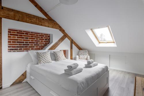 une chambre avec un lit blanc avec des serviettes dessus dans l'établissement L'Ao, à Rennes