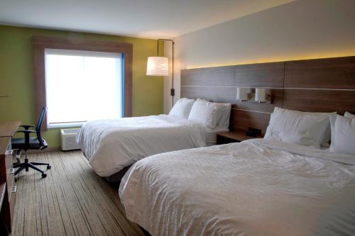a hotel room with two beds and a desk and a window at Holiday Inn Express Rochelle by IHG in Rochelle