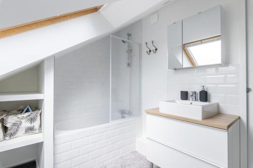 une salle de bain blanche avec un lavabo et une douche dans l'établissement L'Ao, à Rennes