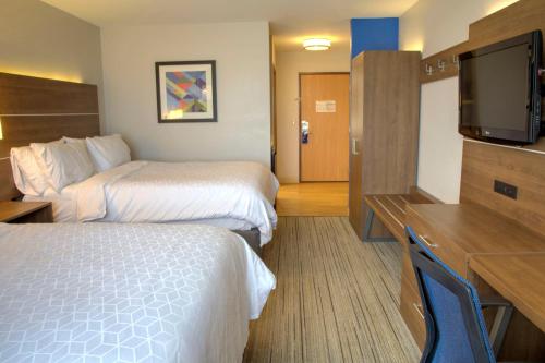 a hotel room with two beds and a flat screen tv at Holiday Inn Express Rochelle by IHG in Rochelle