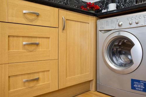 a kitchen with a washer and a washing machine at Velvet 2-bedroom apartment, Clockhouse, Hoddesdon in Hoddesdon