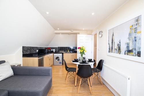 a living room with a couch and a table and chairs at Velvet 2-bedroom apartment, Clockhouse, Hoddesdon in Hoddesdon