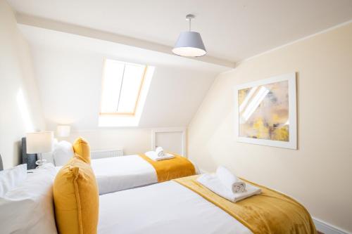 2 camas en un dormitorio con paredes blancas en Velvet 2-bedroom apartment, Clockhouse, Hoddesdon en Hoddesdon