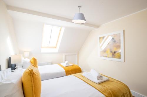two beds in a bedroom with white walls at Velvet 2-bedroom apartment, Clockhouse, Hoddesdon in Hoddesdon