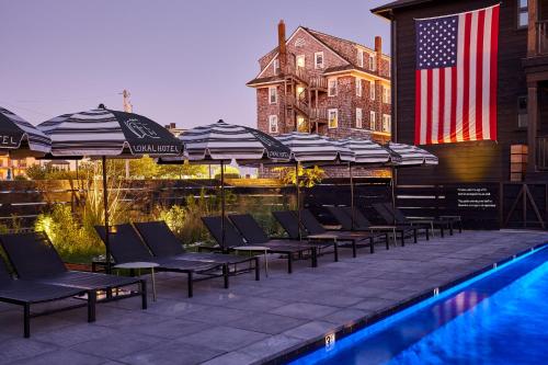 a group of chairs and umbrellas next to a pool at Lokal Hotel Cape May in Cape May
