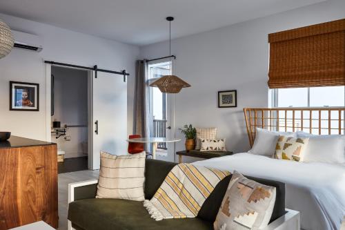 a bedroom with a large bed and a green couch at Lokal Hotel Cape May in Cape May
