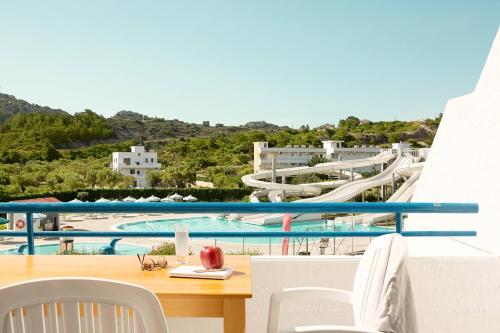 a view of a pool from a balcony with a table and chairs at Cyprotel Faliraki in Faliraki