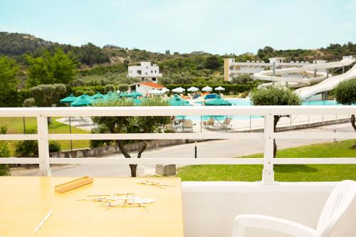 a balcony with a table and a view of a pool at Cyprotel Faliraki in Faliraki