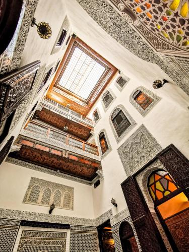 フェズにあるRiad Farahの天井と窓のある華やかなお部屋