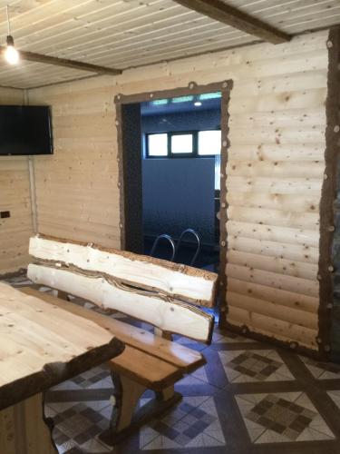 a room with a wooden wall with a table and a door at Карпатский уикенд in Slavske