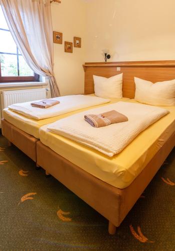 a bedroom with a large bed with yellow sheets at Landpension Minna in Herbsleben