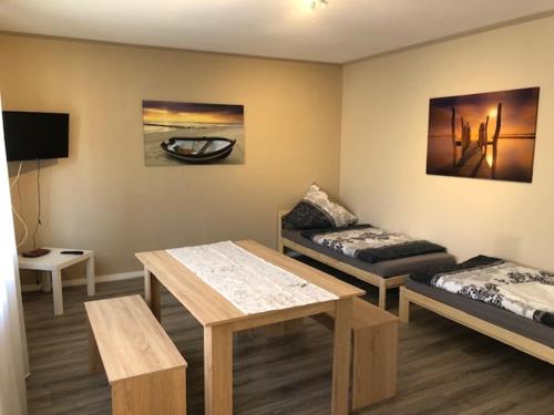 RodenbachにあるMonteur Design Wohnungのベッド2台、テーブル、ソファが備わる客室です。