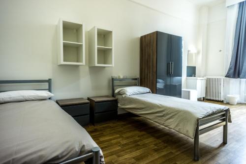 a bedroom with two beds and a blue cabinet at Sandeman-Allen Hostel (Bayswater) in London