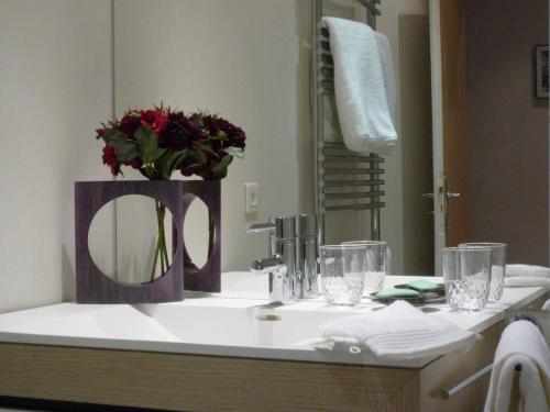 a bathroom sink with a mirror and flowers on it at Gorgeous Paris St Germain des Près in Paris