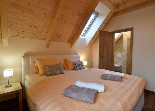 a bedroom with a large bed with two towels on it at Penzion Jizerská Malina in Bedřichov