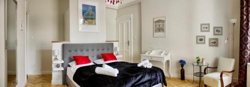 Schlafzimmer mit einem Bett mit roten und weißen Kissen in der Unterkunft Deluxe in the heart of the city in Budapest