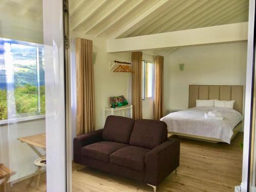 a living room with a couch and a bed at Azores Casa Atlantis in Nordeste