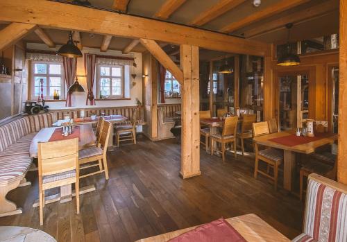 a restaurant with wooden floors and tables and chairs at Gästehaus Alte Bäckerei in Dachwig