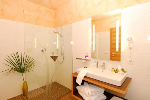 a white bathroom with a sink and a shower at Apparthotel Gartenresidence Nalserhof in Nalles