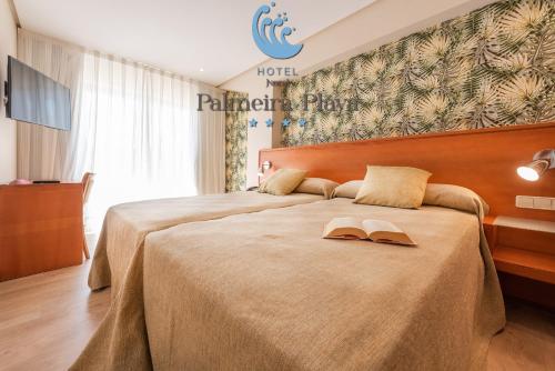 a hotel room with a bed with two hats on it at Hotel Norat Palmeira Playa in Ribeira
