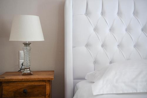 a bedroom with a bed and a lamp on a wooden table at Serenity Luxury Villa, Skiathos in Agia Paraskevi