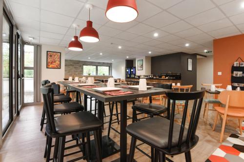 a dining room with a large table and chairs at Appart'City Confort Lille - Euralille in Lille