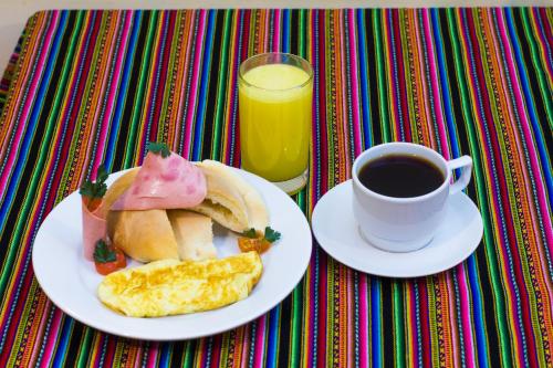 un tavolo con un piatto di cibo e una tazza di caffè di La Parada Cusco Hotel a Cuzco