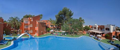 a large swimming pool in a resort with buildings at HSM Club Torre Blanca in Sa Coma