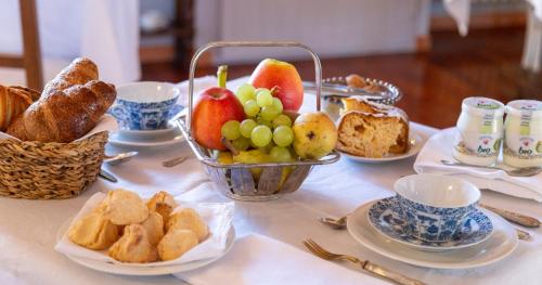a table topped with a tray of bread and fruit at Palazzo Sismonda in Corneliano d'Alba