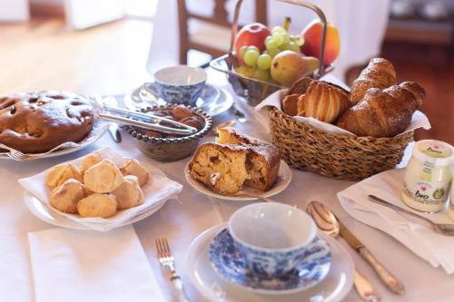 a table topped with baskets of bread and pastries at Palazzo Sismonda in Corneliano d'Alba