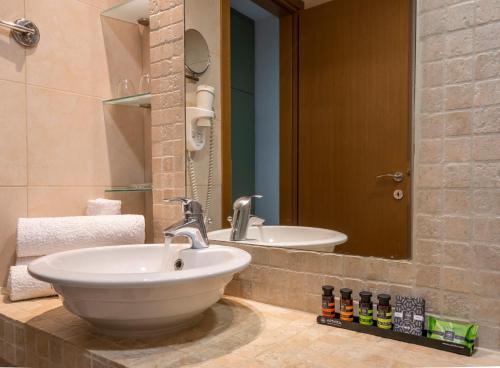 La salle de bains est pourvue d'un lavabo et d'un miroir. dans l'établissement Kastalia Boutique Hotel, à Delphes