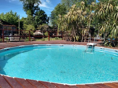 a large swimming pool in a yard with trees at Cabañas Burdeos in Tigre