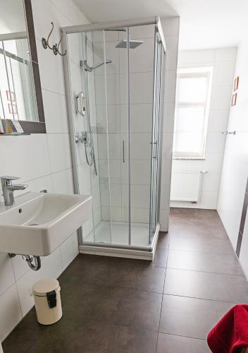 a bathroom with a glass shower and a sink at Hotel Restaurant Mühlenhof Bosse in Dachwig